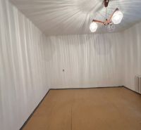 A room in a family house with white walls and a wooden decor floor.