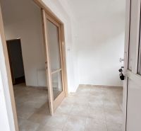 Entrance with light tiles and glass doors in a family house.