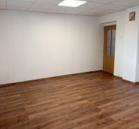 A room in a family house with white walls and a wooden decor floor.