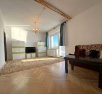 Living room in a two-room apartment with a wooden decor floor and carpets.
