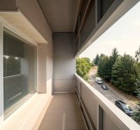Balcony of a 2-room apartment in Bánovce nad Bebravou with a view of the road and trees.