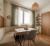 Dining nook with a corner bench and table in a 2-room apartment, interior with wood decor.