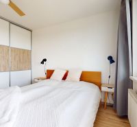 A bedroom with a double bed, nightstands, and a built-in wardrobe in a three-room apartment.