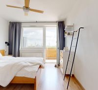 Bright bedroom with a bed, fan, wood-decor flooring, and access to a balcony in a 3-room apartment.