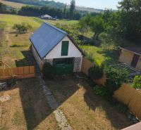 Garden and construction at a family house in Jelenec, surrounded by fields and trees.