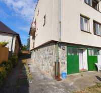 A family house in Jelenec with stone cladding and green doors.
