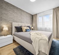 Bedroom with a bed and a nightstand, wooden decor flooring in a 2-room apartment.