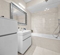 Bathroom in a 2-room apartment with a shower and a bathtub, light tiles.