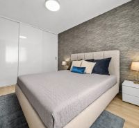 A bedroom in a 2-room apartment with a bed, nightstands, and a floor with a wooden decor.
