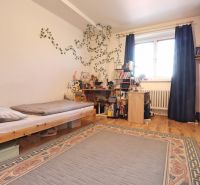 Children's room in a 2-room apartment with a bed, table, and wooden floor decor.