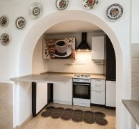 A kitchen in a family house with an arched entrance, decorated with plates and modern details.