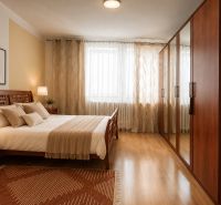 A bedroom in a family house with wooden furniture and a floor with a wooden decor.