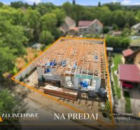 A family house under construction in Marcelová with a completed wooden roof structure.