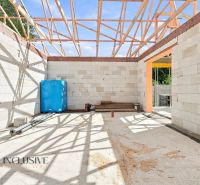 Construction of a family house in Marcelová with exposed wooden trusses and unfinished walls.
