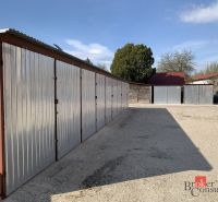 Iron garages on Železničná Street in Šahy. Parking space and cars nearby.