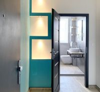 Interior of a 1-room apartment with a wooden decor floor and a modern bathroom.