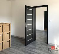 A one-room apartment with a wooden decor floor and boxes in the room.