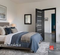 Bedroom with a bed, carpet, lamps, and wooden decor flooring in a studio apartment.