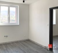 The interior of a one-room apartment with a wooden decor floor and white walls.