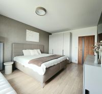 Bedroom in a 4-room apartment with a bed, cabinet, and wooden decor flooring.