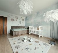 Children's room with wall decorations, wood-patterned flooring, and a white crib in a 4-room apartment.