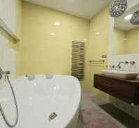 Bathroom with a bathtub in a 4-room apartment, with yellow tiles and a modern sink.
