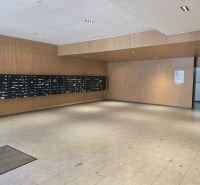 Entrance hall with mailboxes and wooden wall paneling in a 4-room apartment.