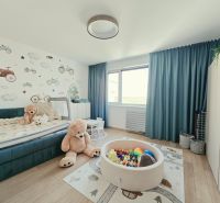 Children's room in a 4-room apartment with a wooden decor floor, toys, and wall decoration.