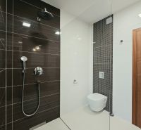 Bathroom with a shower and wall-mounted toilet in a 4-room apartment.