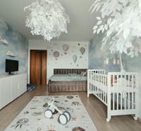 Children's room in a 4-room apartment with a crib, decorative carpet, and wooden-patterned flooring.