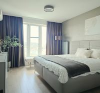 A bedroom in a 4-room apartment with a wood-patterned floor and a large window.