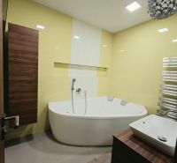 A bathroom with yellow tiles, a corner bathtub, and a wooden cabinet decor in a 4-room apartment.