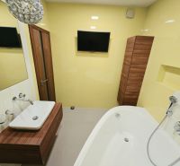 A bathroom with light yellow walls, a bathtub, a sink, and a mirror in a four-room apartment.