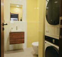 Bathroom in a 4-room apartment, light yellow tiles, sink, toilet, washing machine, and dryer.