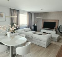 A stylish living room with a comfortable sofa, dining table, and wooden decor flooring in a 4-room apartment.