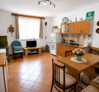 A kitchen in a family house with a fireplace, furniture, and decorations, with a wooden decor floor.