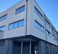 A building with large windows at Komenského 2A 2B in Levice, suitable for commercial spaces.