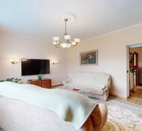 Living room in a 3-room apartment with a sofa, television, and a light carpet.