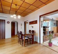 Dining table and chairs on a wooden-decor floor in a 3-room apartment.
