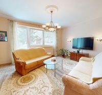 Living room with carpets, sofas, and a television in a 3-room apartment.