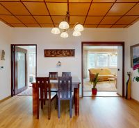 Dining table and chairs, wooden decor flooring, picture and decorations in a 3-room apartment.