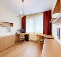 A room in a 3-room apartment with a wooden decor floor and light furniture.