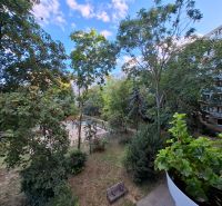 View from the balcony of a 3-room apartment on Hospodárska Street in Trnava, with a playground and trees.