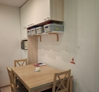 Dining area with a table and chairs in a 3-room apartment. Floor with wood decor.