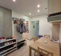 Dining room in a 3-room apartment with open space and wooden decor flooring.