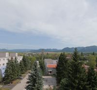 A view of Mudrochova Street in Rajec with a view of nature and buildings.