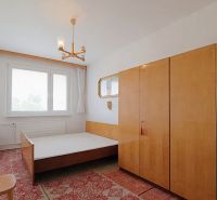 A bedroom with a bed, wardrobes, and a carpet in a two-room apartment.