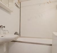 Bathroom in a 2-room apartment with a bathtub, sink, and washing machine.