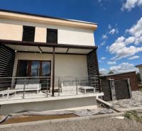 A family house in Kendice with a terrace, outdoor seating, and a sky with white clouds.