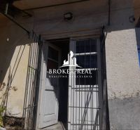 Entrance door with a metal grid and the wall of a family house in Csobád.